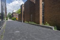 a brick street in the city with trees on the side of the building and a curb with brick pavers in between the buildings