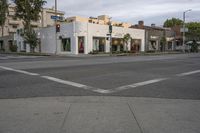 a corner at an intersection with an empty building in the background and white painted signage at right