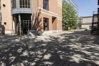 a picture of some buildings on a sunny day and one is empty with chairs on the sidewalk and there are no people or vehicles outside