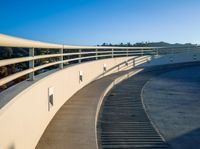 a set of stairs sitting on top of a slope near trees and hills under a clear blue sky