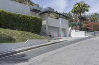 a person riding a motorcycle on the side of a road next to a white building