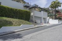 a person riding a motorcycle on the side of a road next to a white building