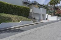 a person riding a motorcycle on the side of a road next to a white building