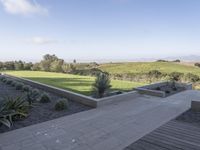 an outdoor terrace with concrete seating and views to the valley, trees, and grasses