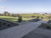 an outdoor terrace with concrete seating and views to the valley, trees, and grasses