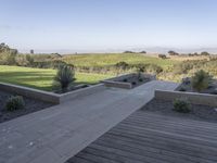 an outdoor terrace with concrete seating and views to the valley, trees, and grasses