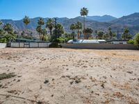 a dirt field with mountains in the background at a residential property area that is being sold