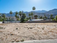 a dirt field with mountains in the background at a residential property area that is being sold