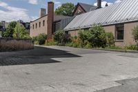 there is a skateboard that is in the driveway near a building and trees on the side