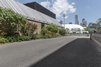 a man is walking down the paved path in front of a building and several green trees