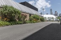 a man is walking down the paved path in front of a building and several green trees