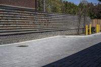 an outdoor space in between a fence and a building on a clear day with no people or cars