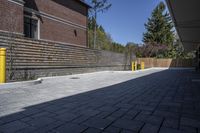 an outdoor space in between a fence and a building on a clear day with no people or cars