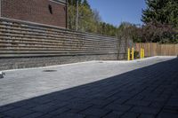 an outdoor space in between a fence and a building on a clear day with no people or cars