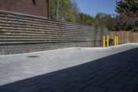 an outdoor space in between a fence and a building on a clear day with no people or cars