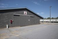 a barn that is gray with no windows and door open with the name a written on the side