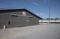 a barn that is gray with no windows and door open with the name a written on the side