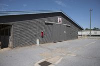 a barn that is gray with no windows and door open with the name a written on the side