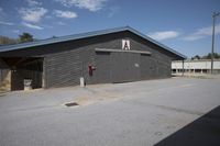a barn that is gray with no windows and door open with the name a written on the side