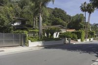 a residential road surrounded by trees and hedges and a sign for a parking area on the side