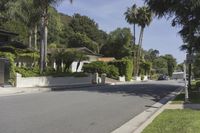 a residential road surrounded by trees and hedges and a sign for a parking area on the side