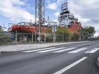 a big boat docked near a street on a cloudy day, in a rural area