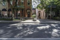 the corner of a residential road is pictured with a tree on it's right side