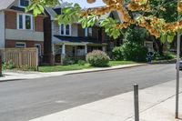 a row of houses and a fence line a street with a parking meter in the foreground