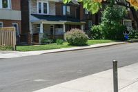 a row of houses and a fence line a street with a parking meter in the foreground