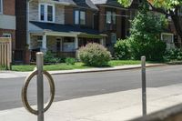 a row of houses and a fence line a street with a parking meter in the foreground