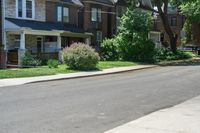 a row of houses and a fence line a street with a parking meter in the foreground