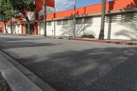 an empty street is seen in front of a building with several palm trees on both sides of the street