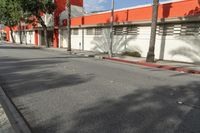 an empty street is seen in front of a building with several palm trees on both sides of the street