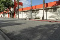 an empty street is seen in front of a building with several palm trees on both sides of the street