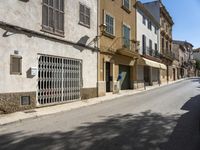 an empty street with old buildings lining it and cars parked on the side of the road