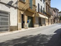 an empty street with old buildings lining it and cars parked on the side of the road