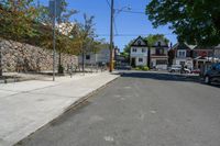 there is a street that looks very quiet with cars parked and trees in front of it