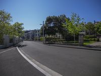 a street with houses and some trees on it near the fenced off area and parking lot