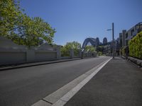 empty city street in front of the sydney harbour bridge on a sunny day with clear sky