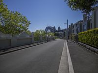 empty city street in front of the sydney harbour bridge on a sunny day with clear sky