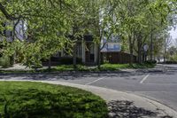 an empty residential street lined with trees and sidewalks on both sides of the road as well as sidewalks on the right of it