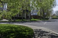 an empty residential street lined with trees and sidewalks on both sides of the road as well as sidewalks on the right of it