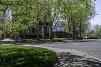 an empty residential street lined with trees and sidewalks on both sides of the road as well as sidewalks on the right of it