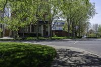 an empty residential street lined with trees and sidewalks on both sides of the road as well as sidewalks on the right of it