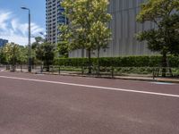 empty road with white lines on the streets of city area against cloudy blue sky on a sunny day