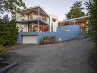 a large house sitting on the side of a road with stairs up and a roof on