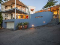 a large house sitting on the side of a road with stairs up and a roof on