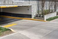 two people in a parking garage attached to an awning and a bicycle on a sidewalk