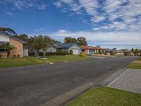 a row of houses on a residential street in a suburb area with grass and shrubs