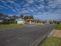 a row of houses on a residential street in a suburb area with grass and shrubs